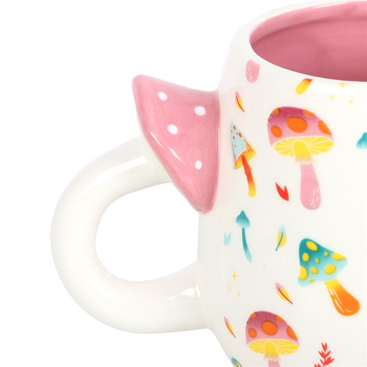 Mug with pink handle and colorful mushroom design on a white background
