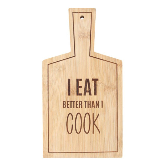 Wooden cutting board with 'I Eat Better Than I Cook' text on a white background